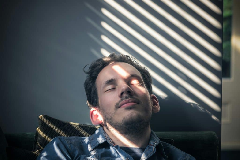 man resting eyes window