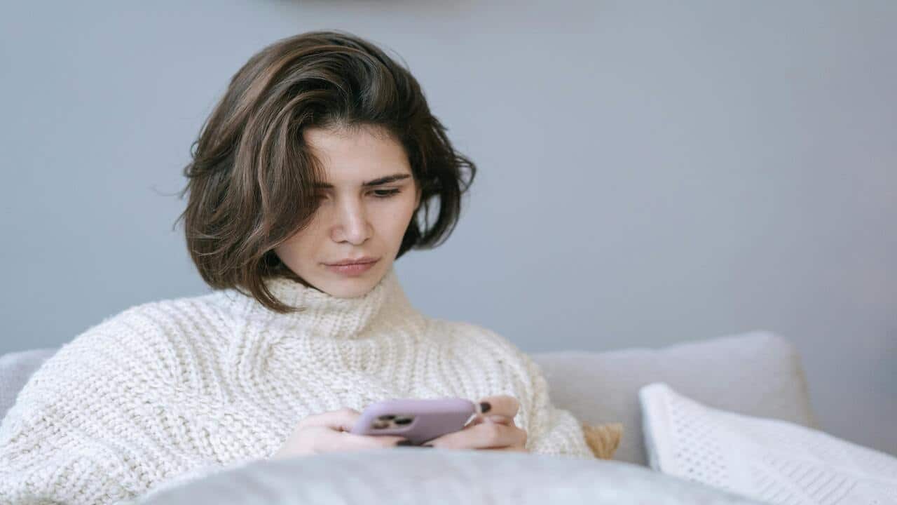 A woman looking sad while texting
