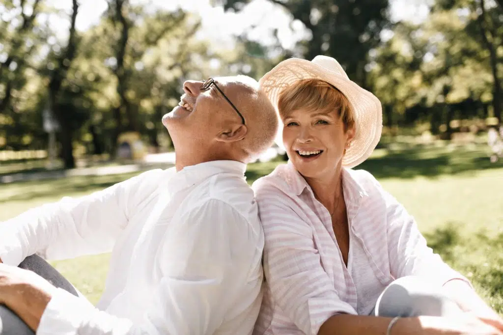 Happy old couple sitting in park