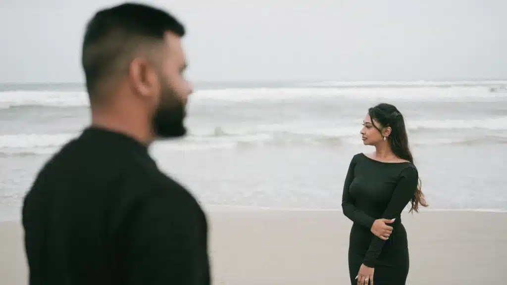 A man and a woman standing on a beach.