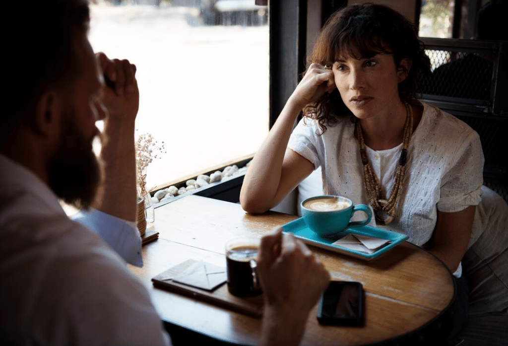 Woman in serious conversation with man inside cafe