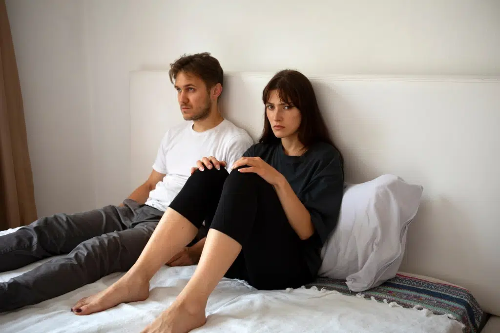 A man and woman sitting on the bed