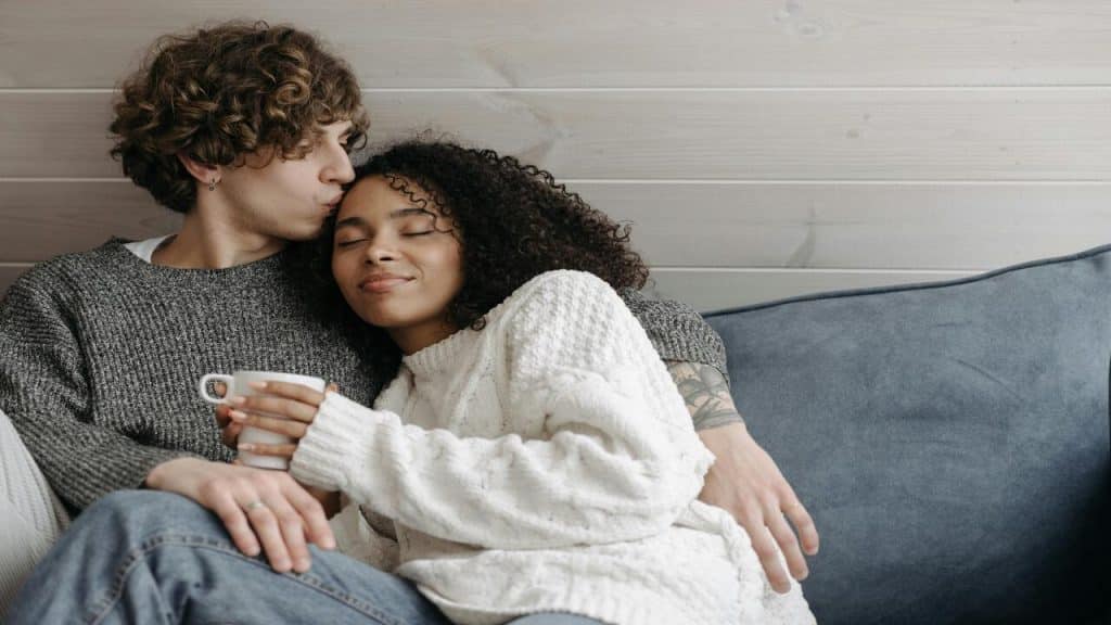 A couple snuggling on the couch