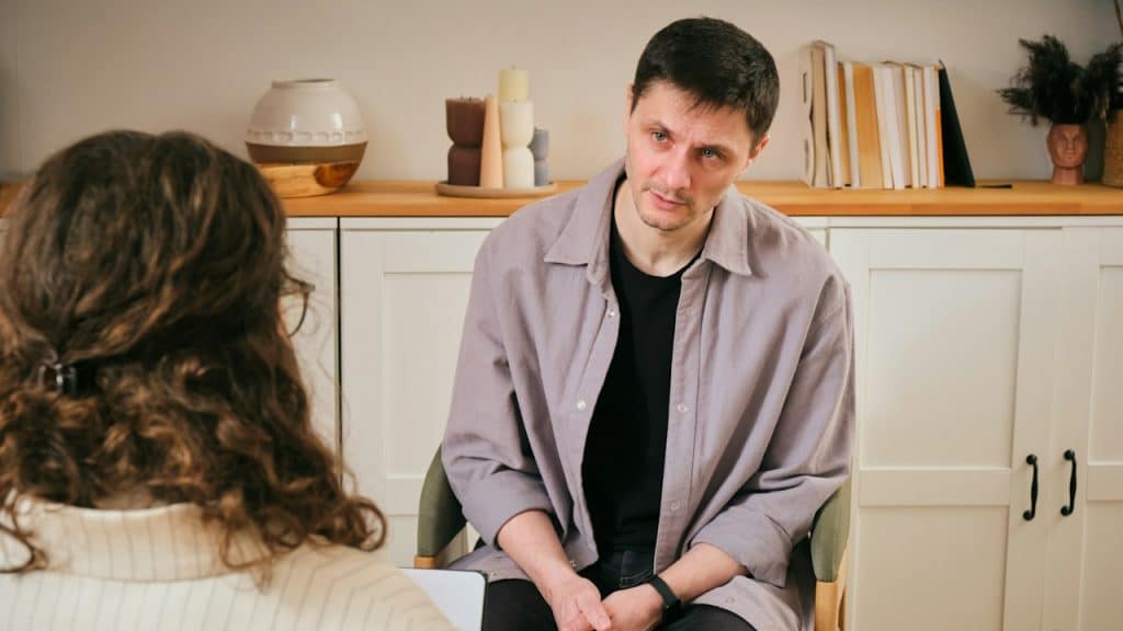 A man sitting in a chair next to a woman.