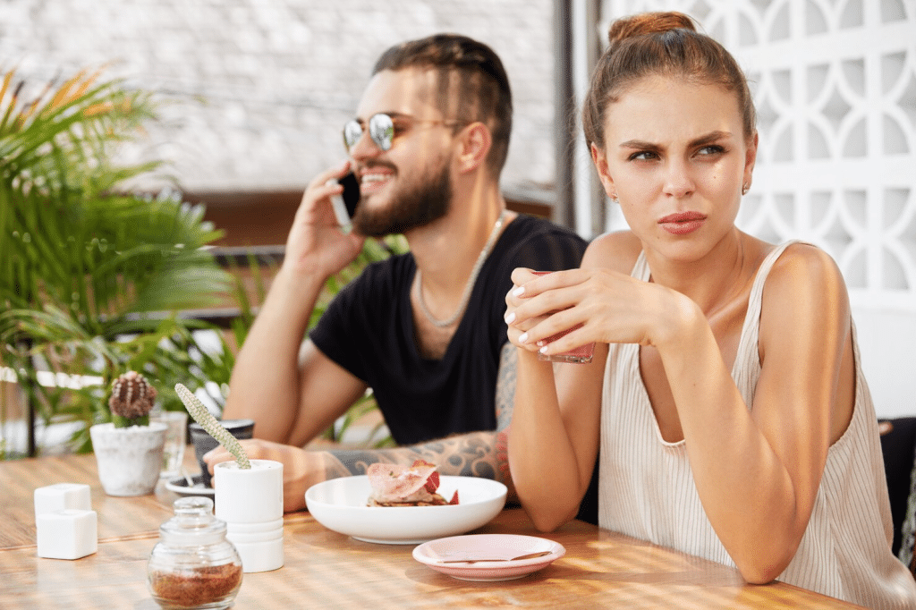 A man staying on phone and a woman getting annoyed