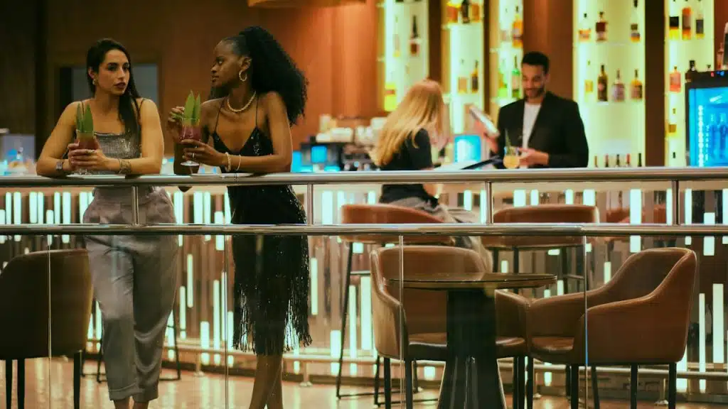 Women enjoying drinks and talking at a bar.