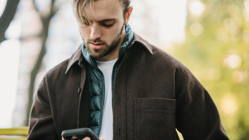 A man looking at his phone outdoors.