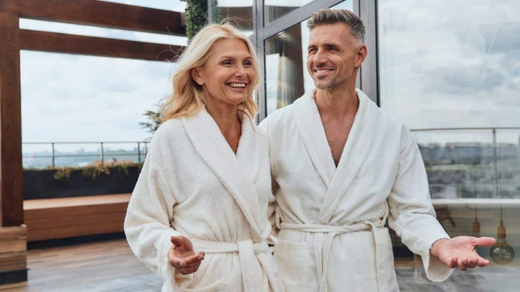 Beautiful, mature couple in bathrobes relaxing in a luxury hotel outdoors.