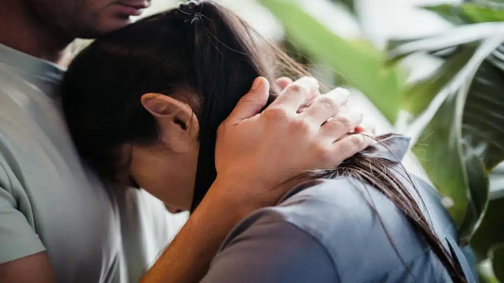 A woman leaning on a man’s chest 