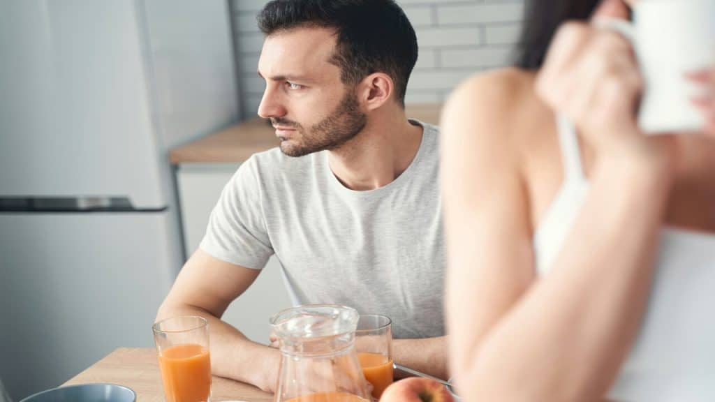 A man looking sad during breakfast with his wife