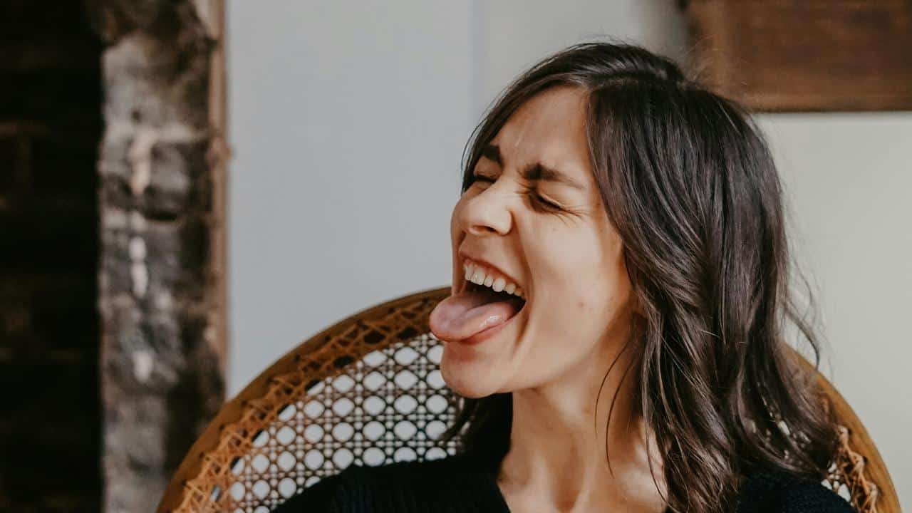 A woman laughing with her tongue out