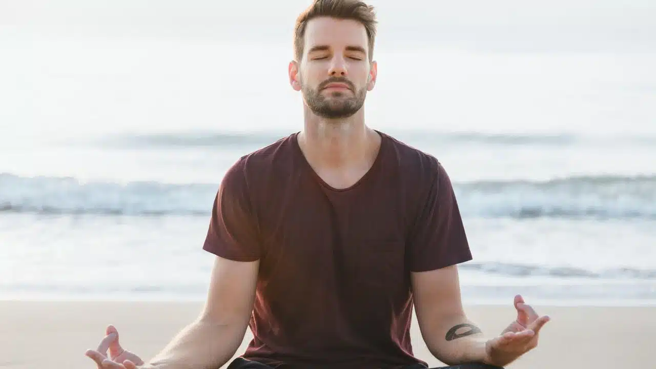 A man meditating on a beach