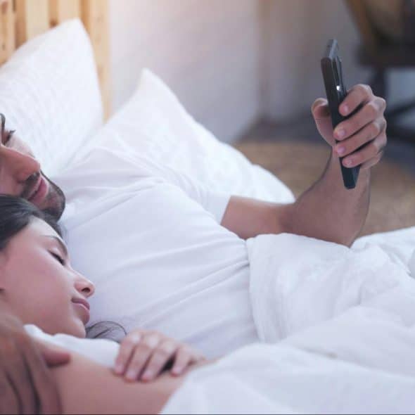 Woman sleeping and a man using a phone