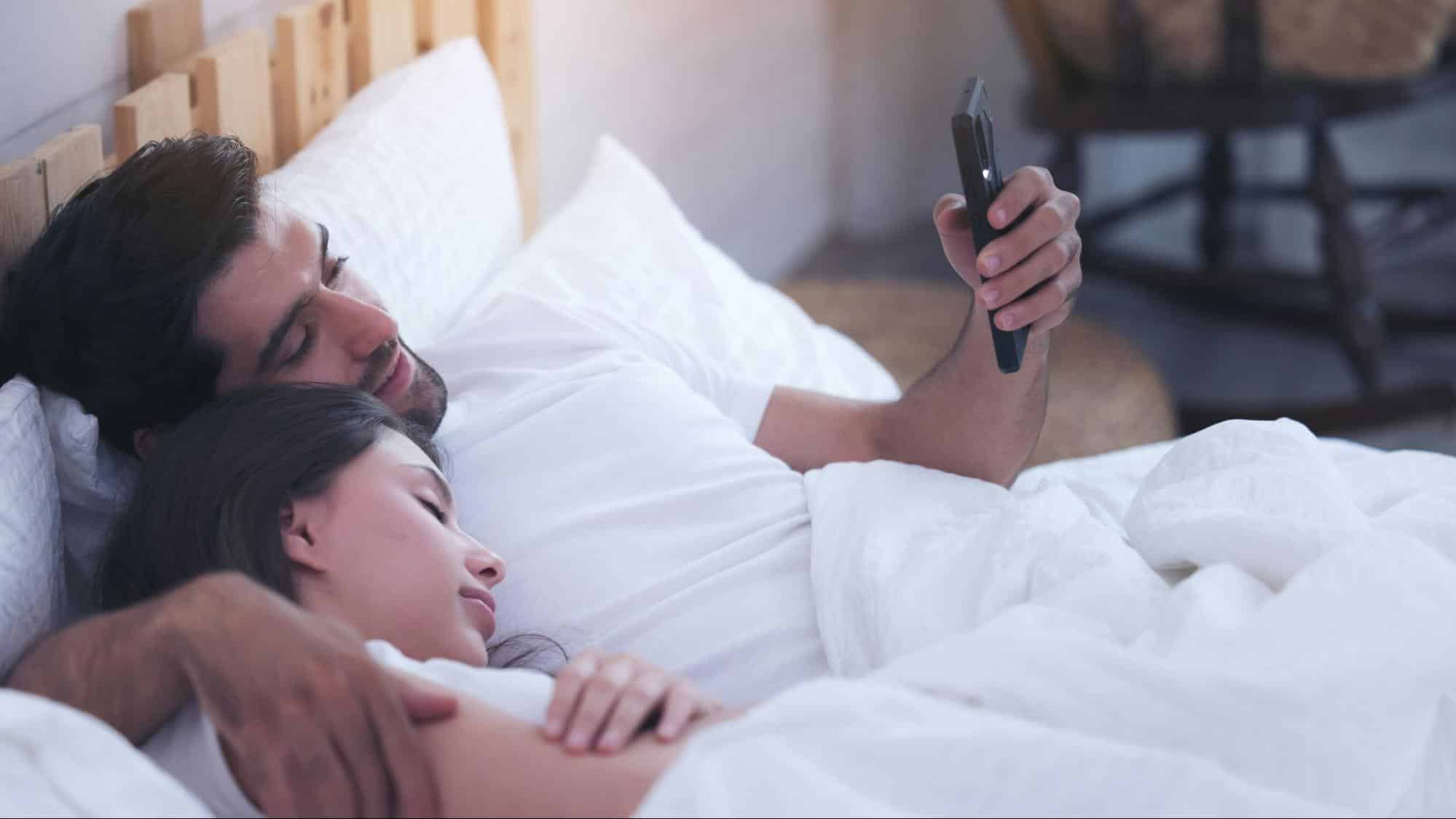 Woman sleeping and a man using a phone