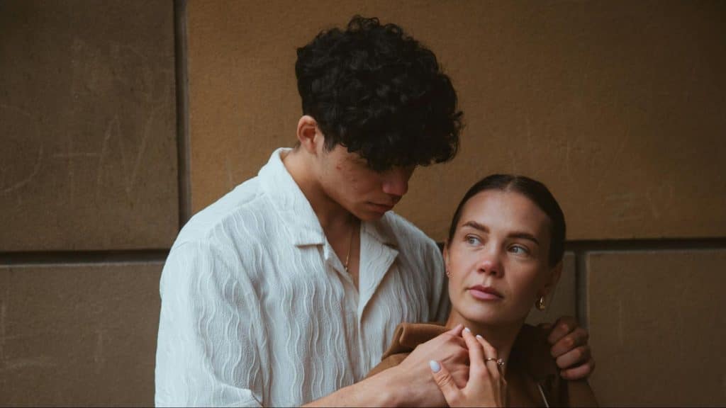 A man holding woman’s shoulder