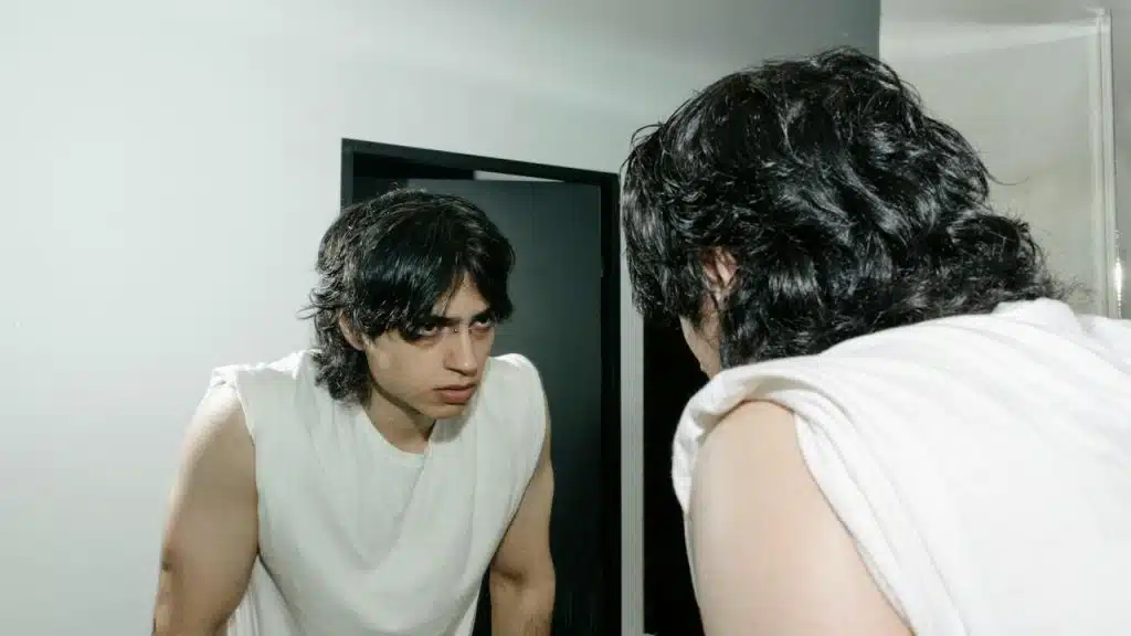 An angry man looking at himself in the mirror.