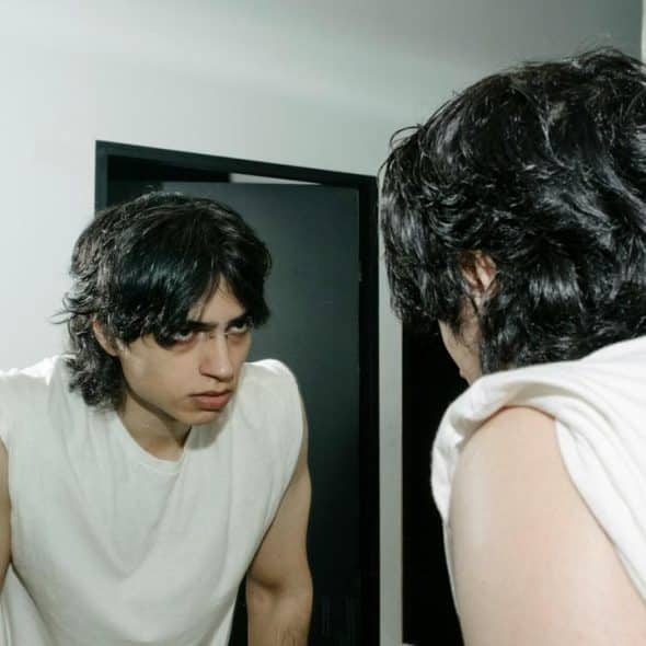 An angry man looking at himself in the mirror.