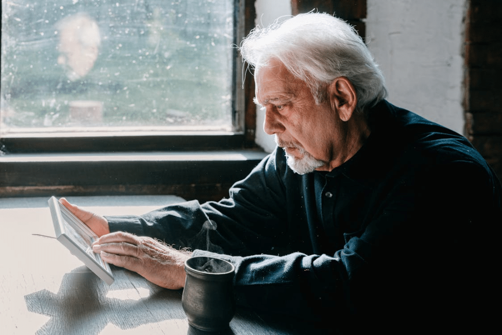 Mature man using tablet sitting down at desk