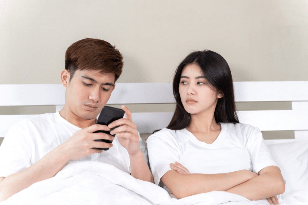 Young woman sitting on bed with feeling upset with her partner