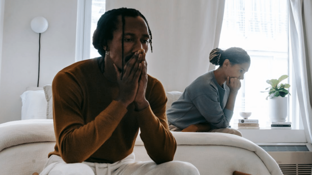 A couple looking sad in the bedroom