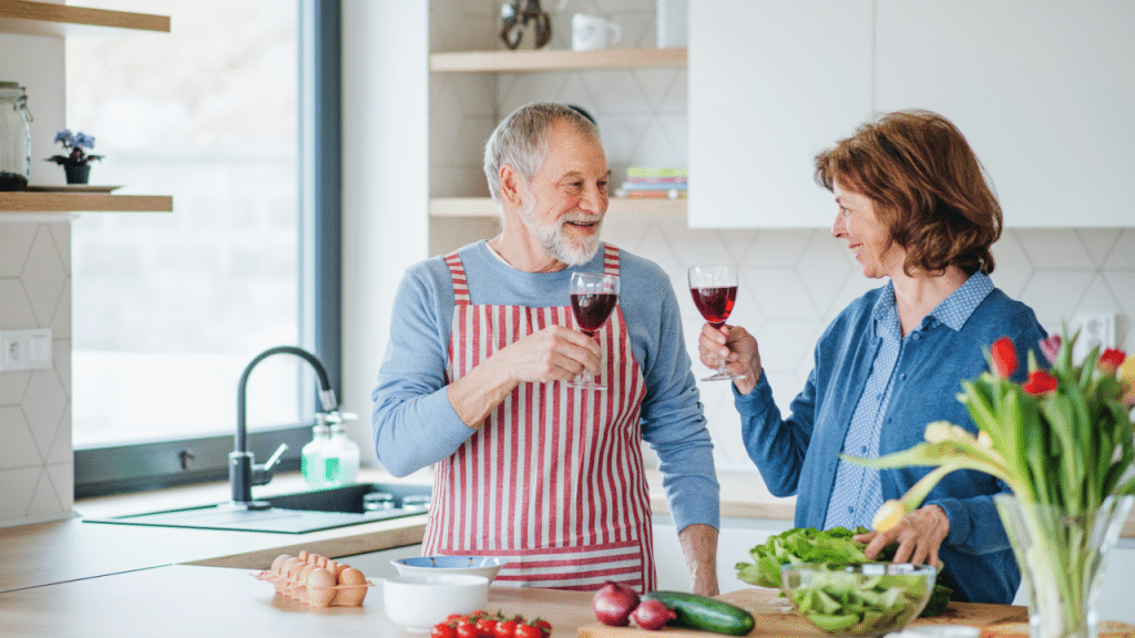 A couple clinking glasses in the kitchen