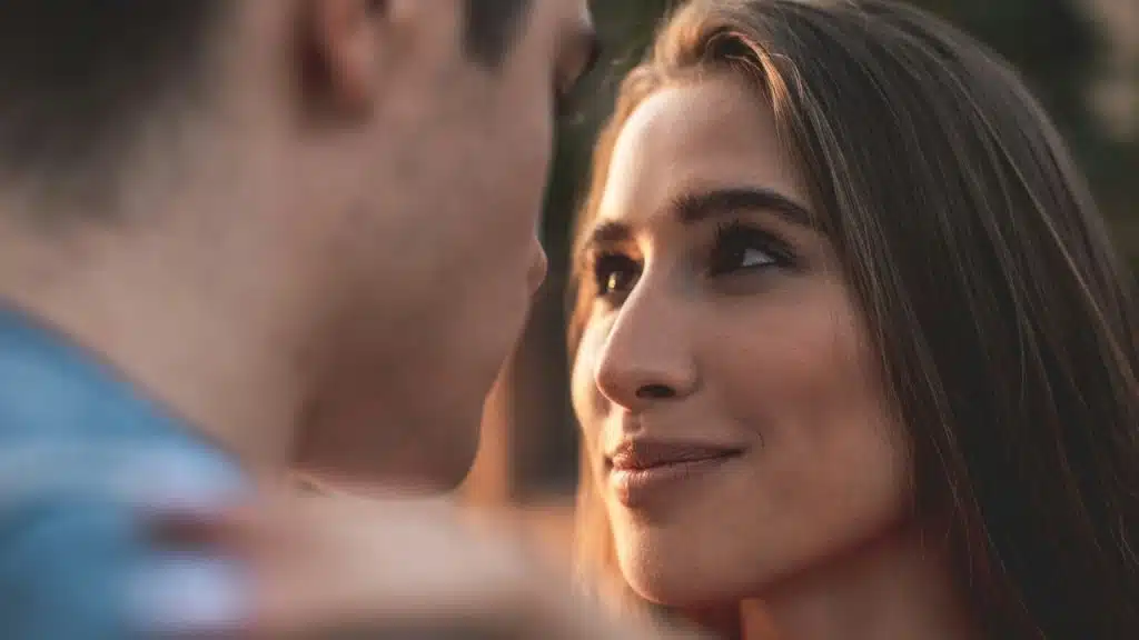 A woman staring into a man’s eyes while smiling.