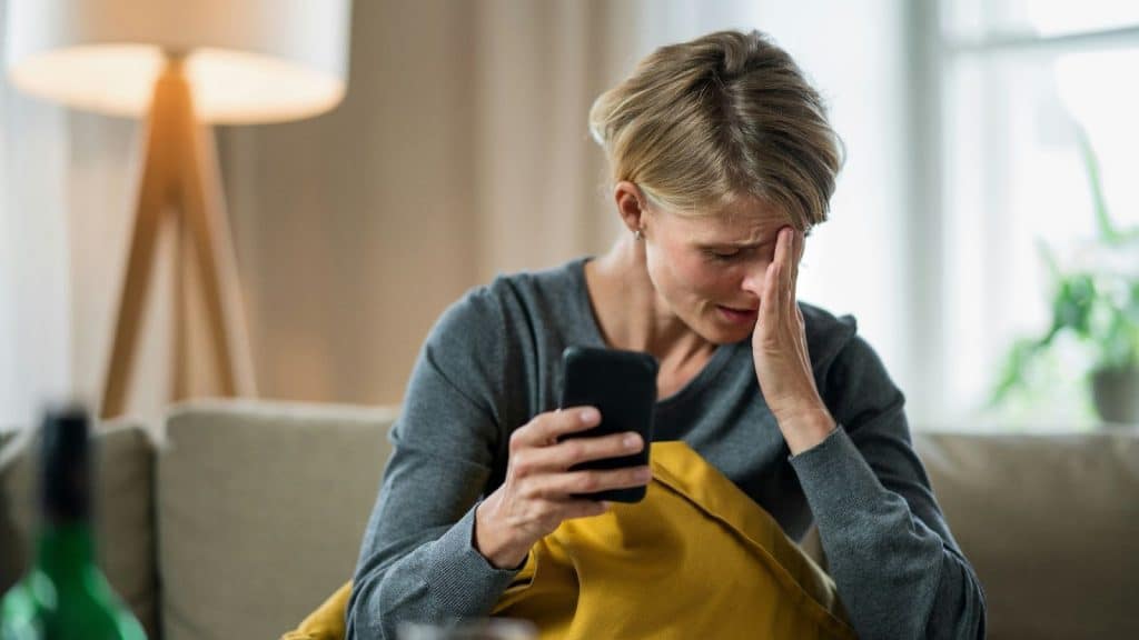 Woman crying while holding a phone