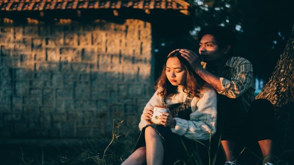 couple sitting close but with a sense of emotional distance