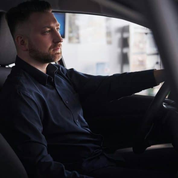A man sitting in the driver’s seat of a car.