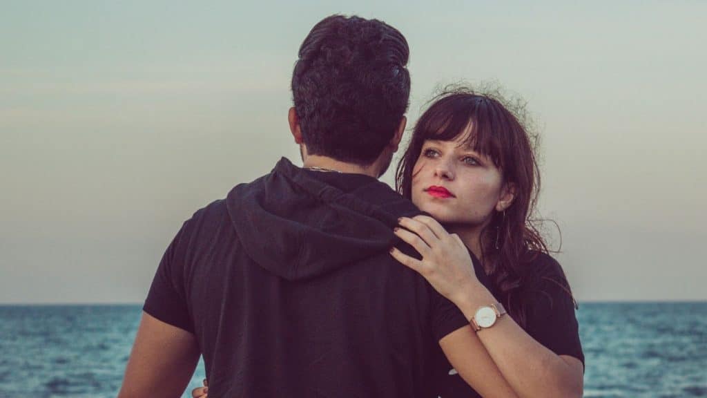 A woman hugging a man but emotionless