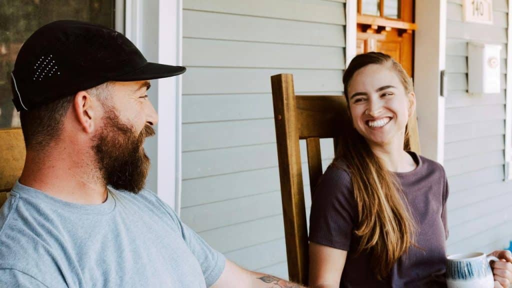 A smiling couple sitting on a porch
