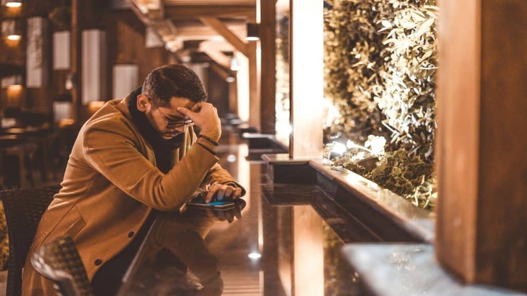 man putting phone down calmly