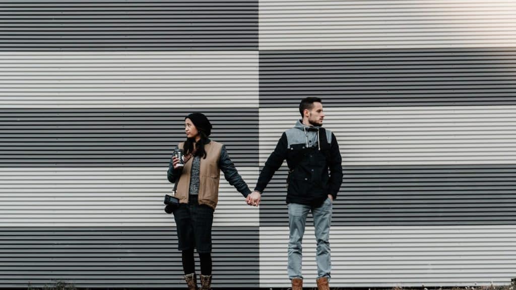 A man and woman holding hands but both are proud to be with each other