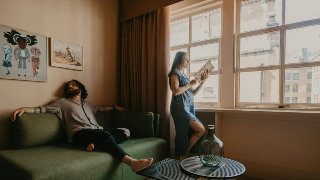 A man sitting and a woman busy reading a book