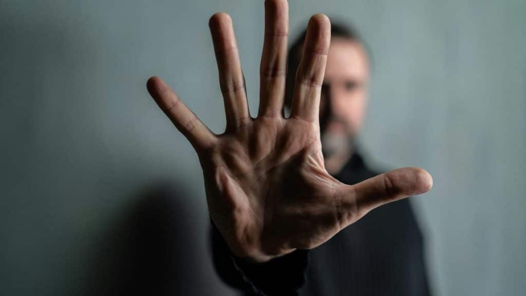 A man holding up his hand toward the camera.