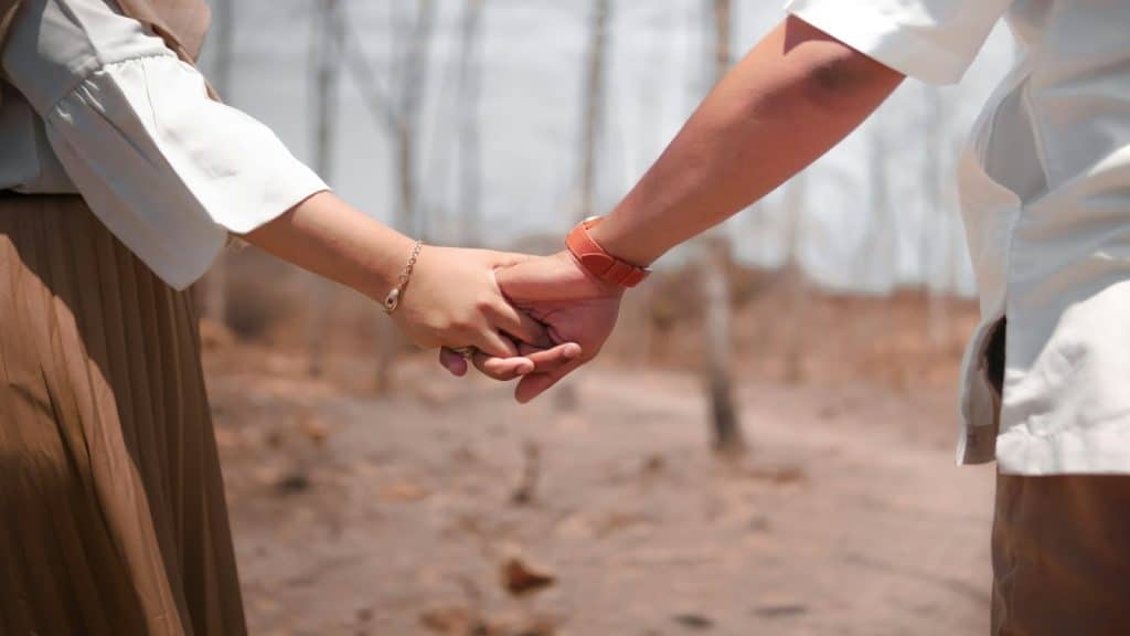 couple holding hands gently
