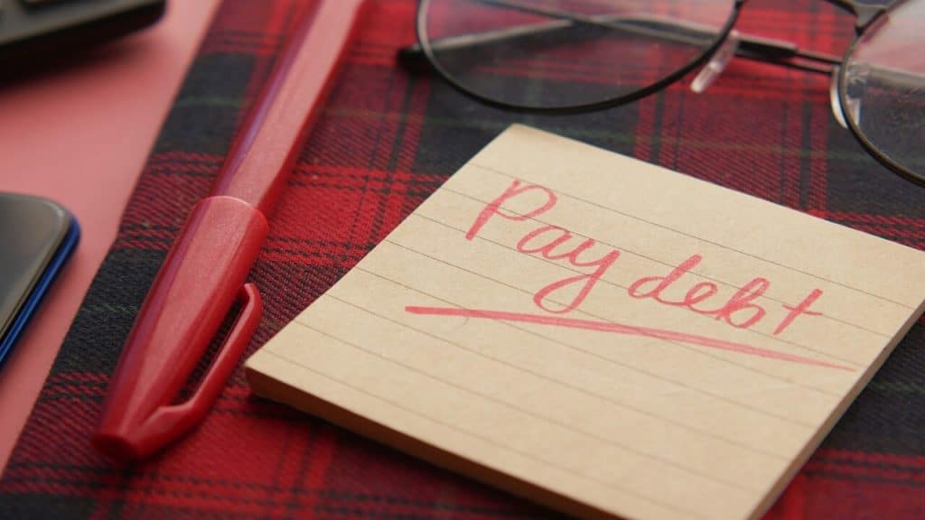 A handwritten note saying “pay debt”