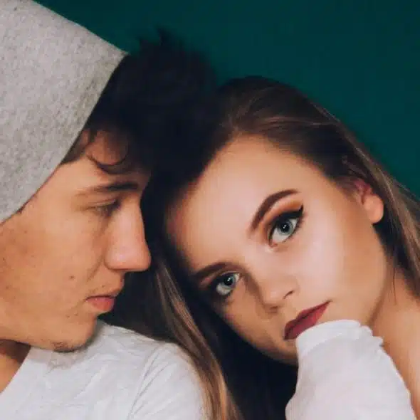 A man standing beside a woman while staring.
