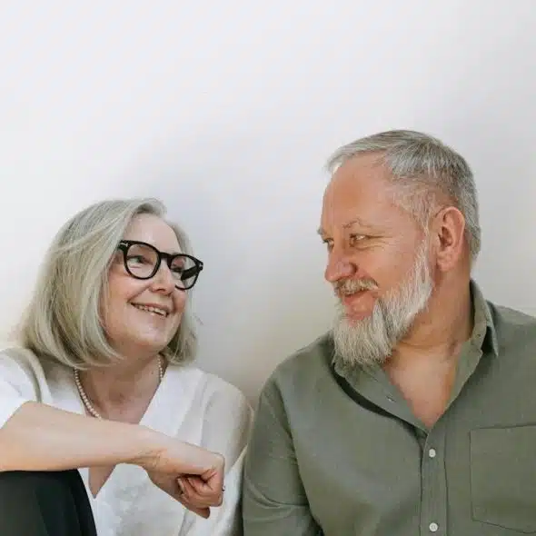 An older woman looking at each other and smiling.
