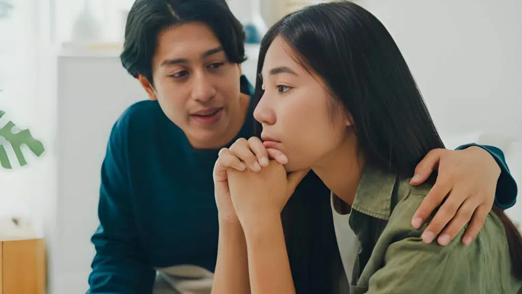 Sad woman ignoring man trying to talk to her