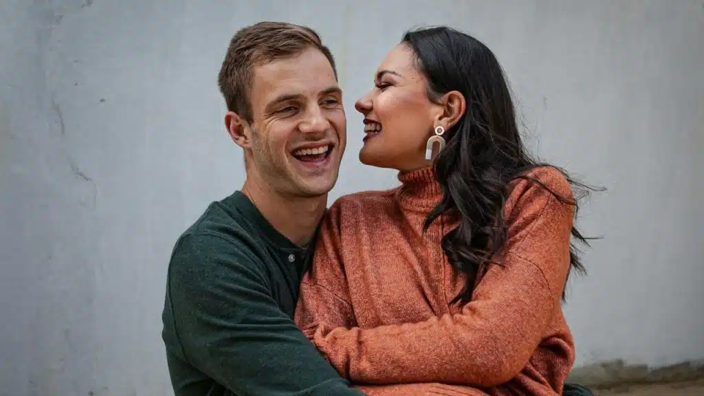 A man and a woman smiling and hugging each other.