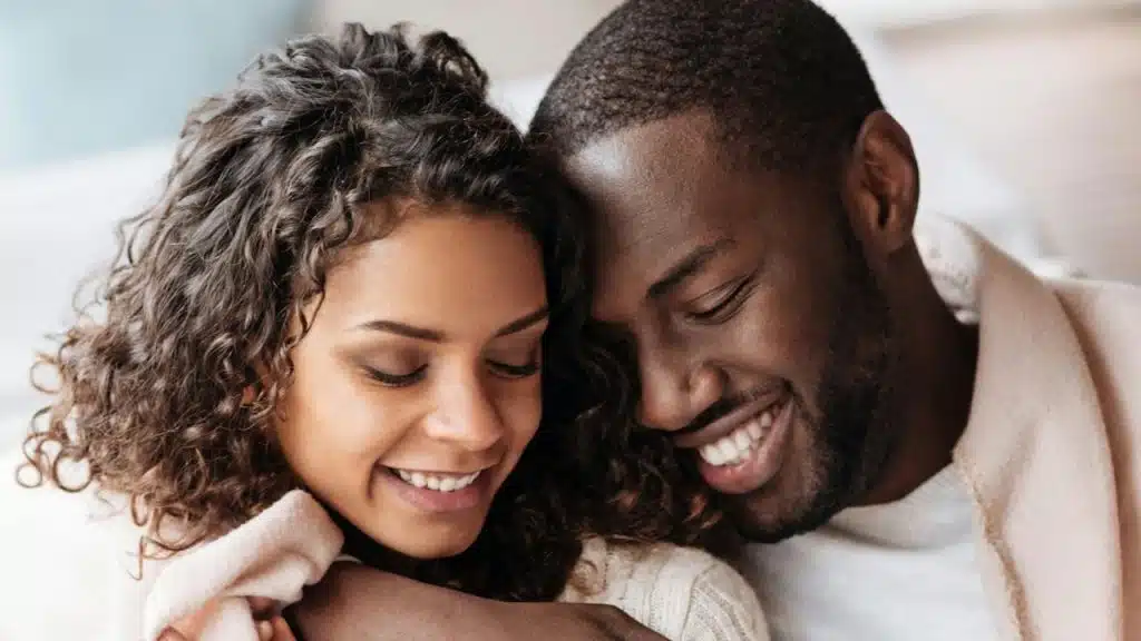 A man snuggling with a woman.