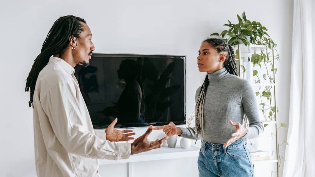 Black couple having a tense discussion or argument in a living room.
