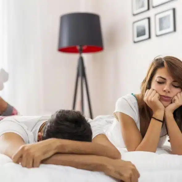 A couple lying in bed having an argument.