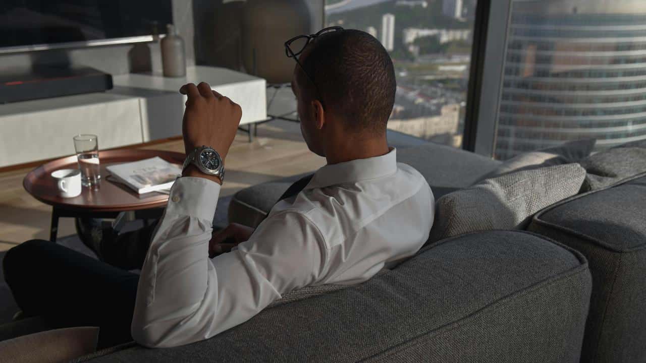 A person in a dress shirt sitting on a sofa.
