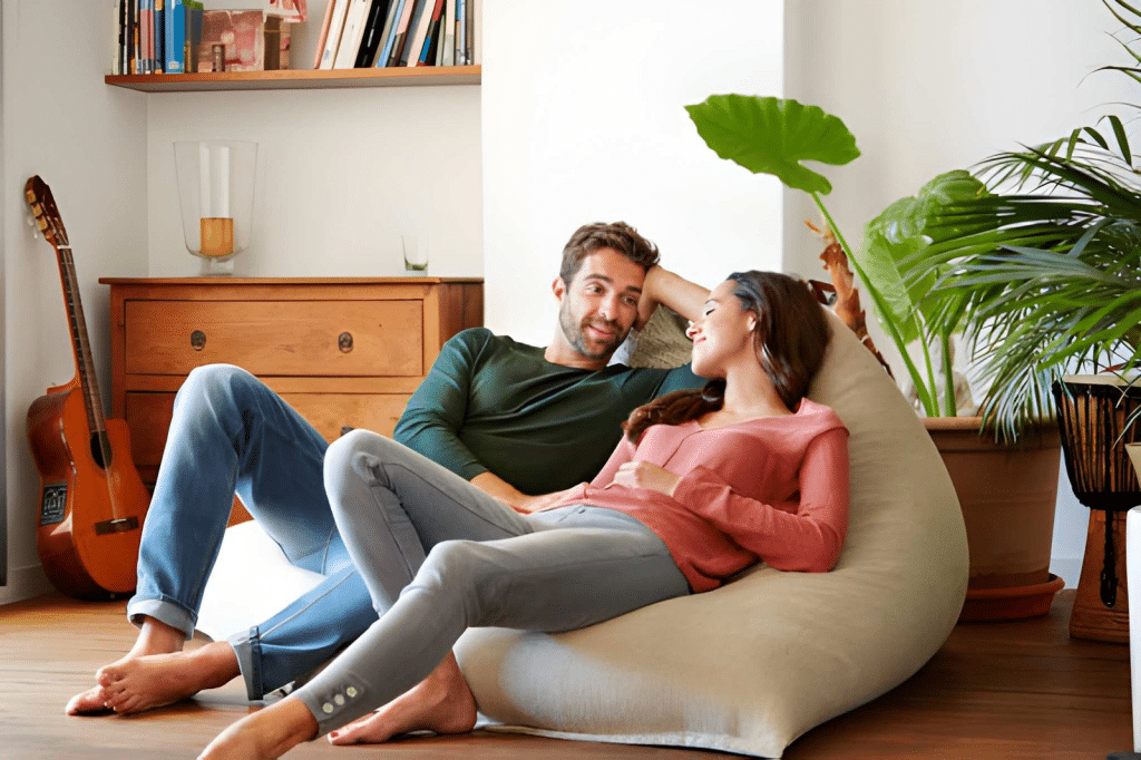 Smiling young couple talking together while relaxing on a beanbag