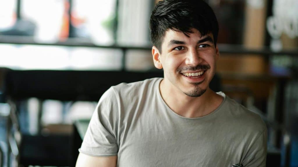 A man smiling while looking to the side indoors