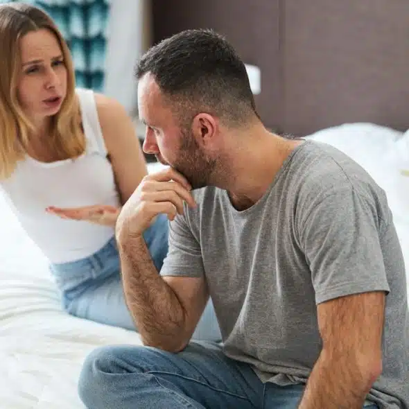A couple discussing their problems while they are sitting in their bedroom.