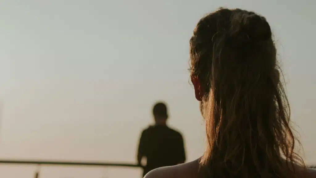 Selective focus photography of a woman facing a body of water.