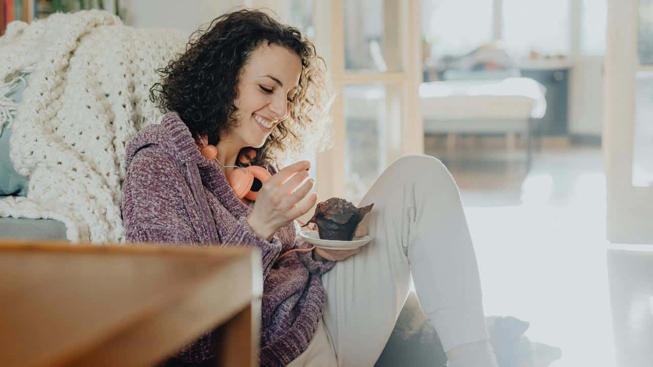 A smiling woman sits indoors